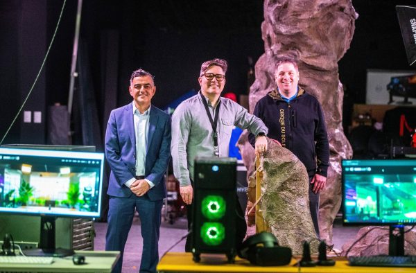 Employees from New Media Manitoba Louie, Jon and Matt stand on a virtual production stage surrounded by screens and props.