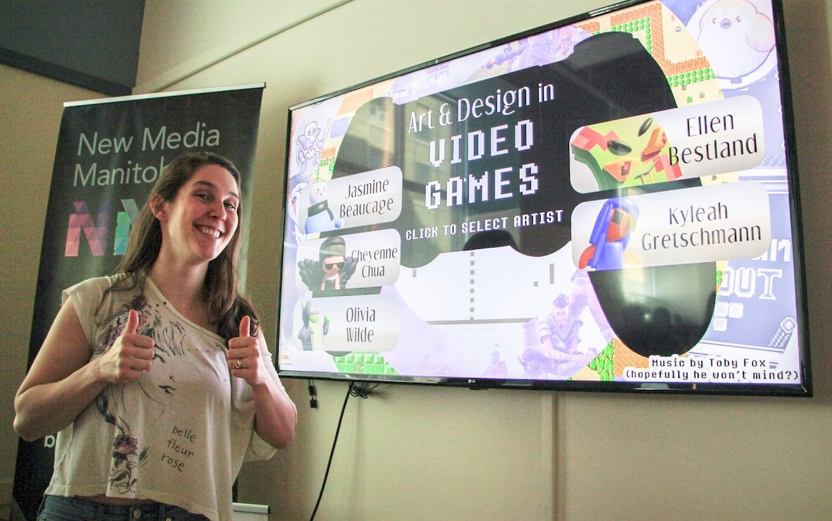 Rebecca Harrison gives a double thumbs up to the camera, in front of a screen that says "Art and Design in Video Games"